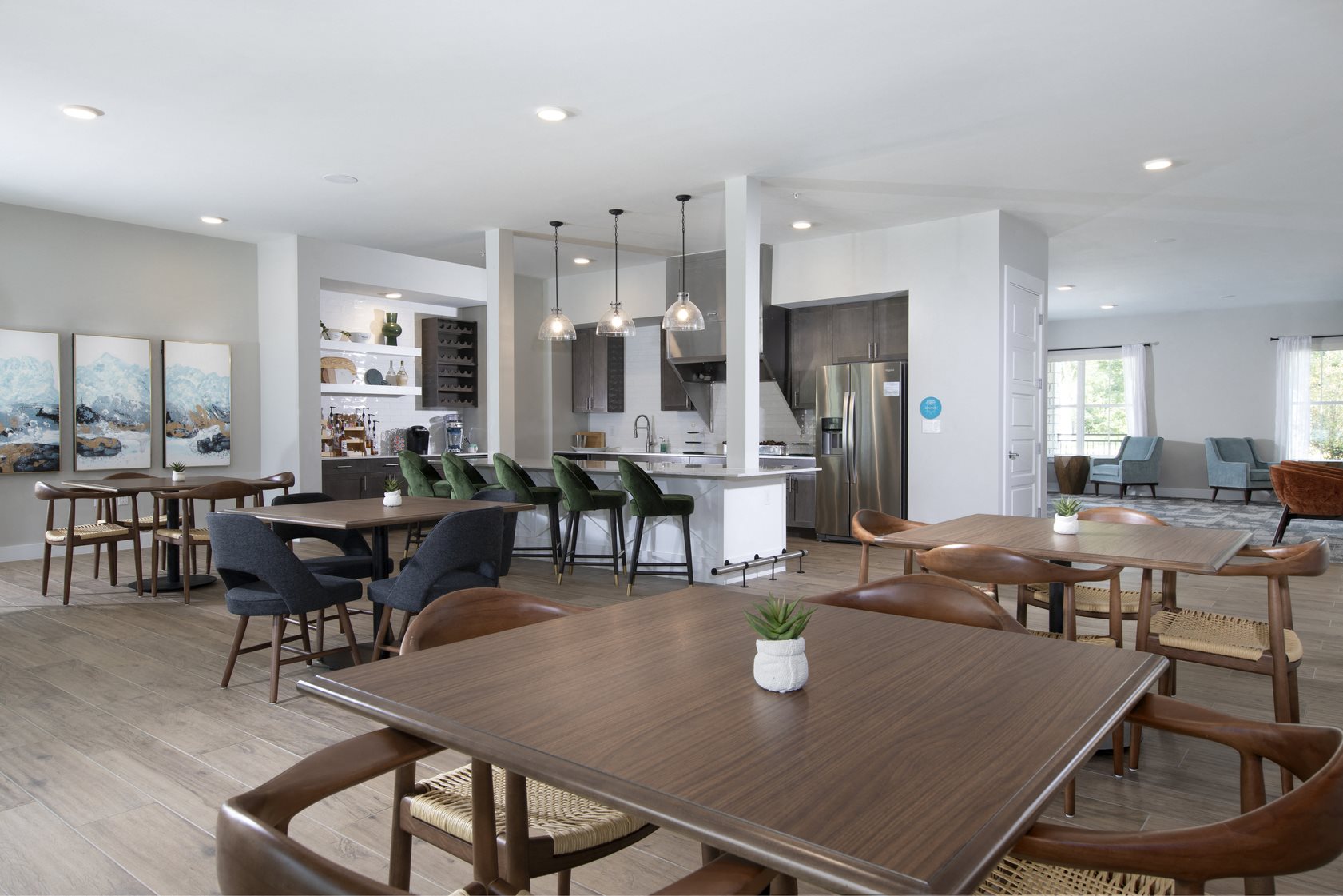 a communal clubhouse dining room opening up to a kitchen at a senior apartment community